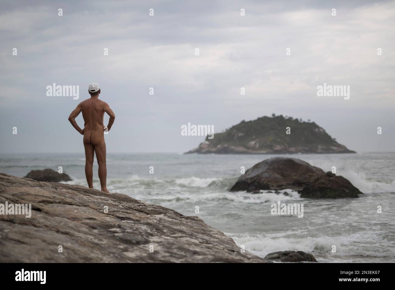 Nudist beach peeping  Pedro Ribeiro looks out at the sea from Abrico beach, recently designated  as nudist after a 20-year-battle, in Rio de Janeiro, Brazil, Thursday, Dec.  4, 2014. The law passed last month frees
