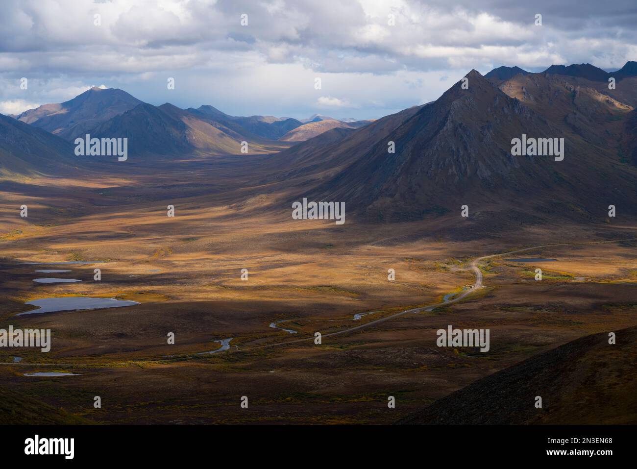 The Dempster Highway winds its way through the landscape as seen from the summit of Mount Adney. Autumn creates a kaleidoscope of color on the tundra Stock Photo
