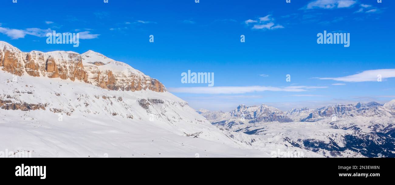 View of the snow covered mountain peaks and blue sky of the Sella Group in Val di Fasso near the Canazei Ski Resort Town in the Trento District Stock Photo