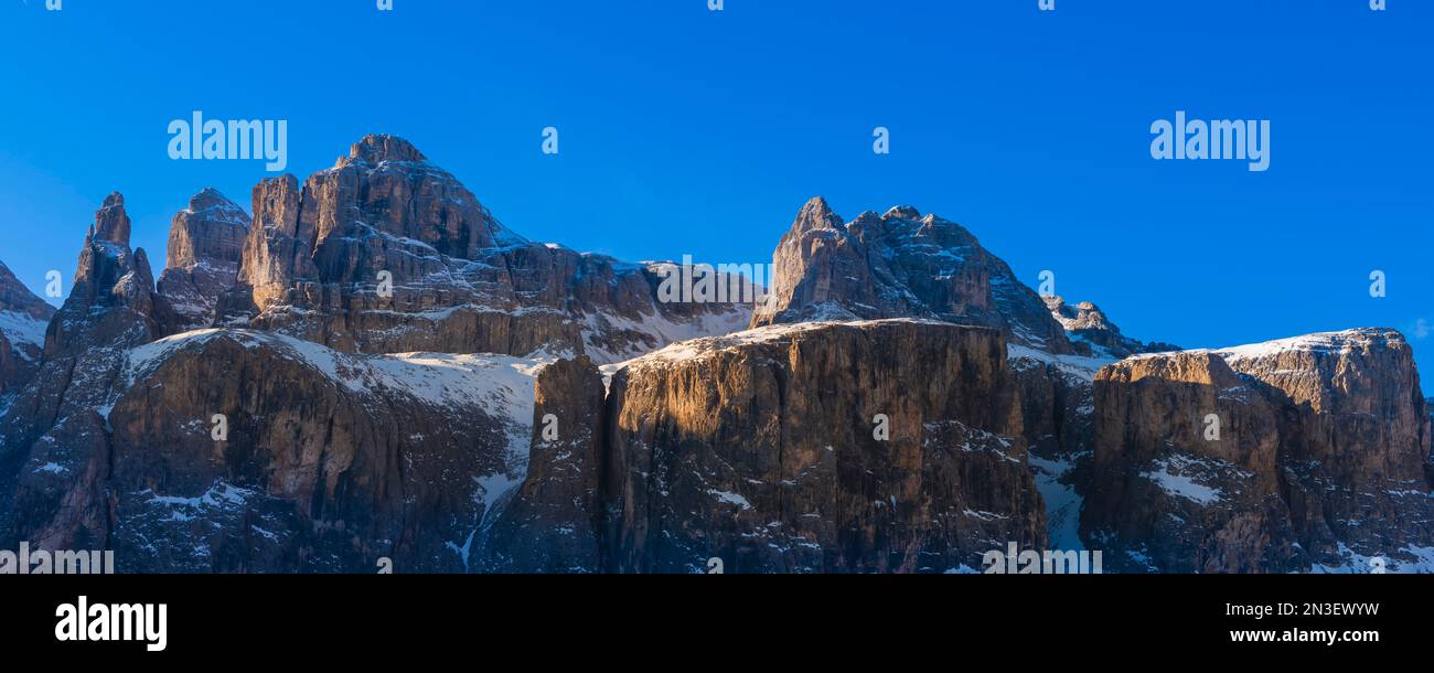 Rocky peaks of the Sella Group covered in snow in Val Di Mezdi against a bright blue sky at Colfosco Corvara in Alta Badia Mountain Region Stock Photo