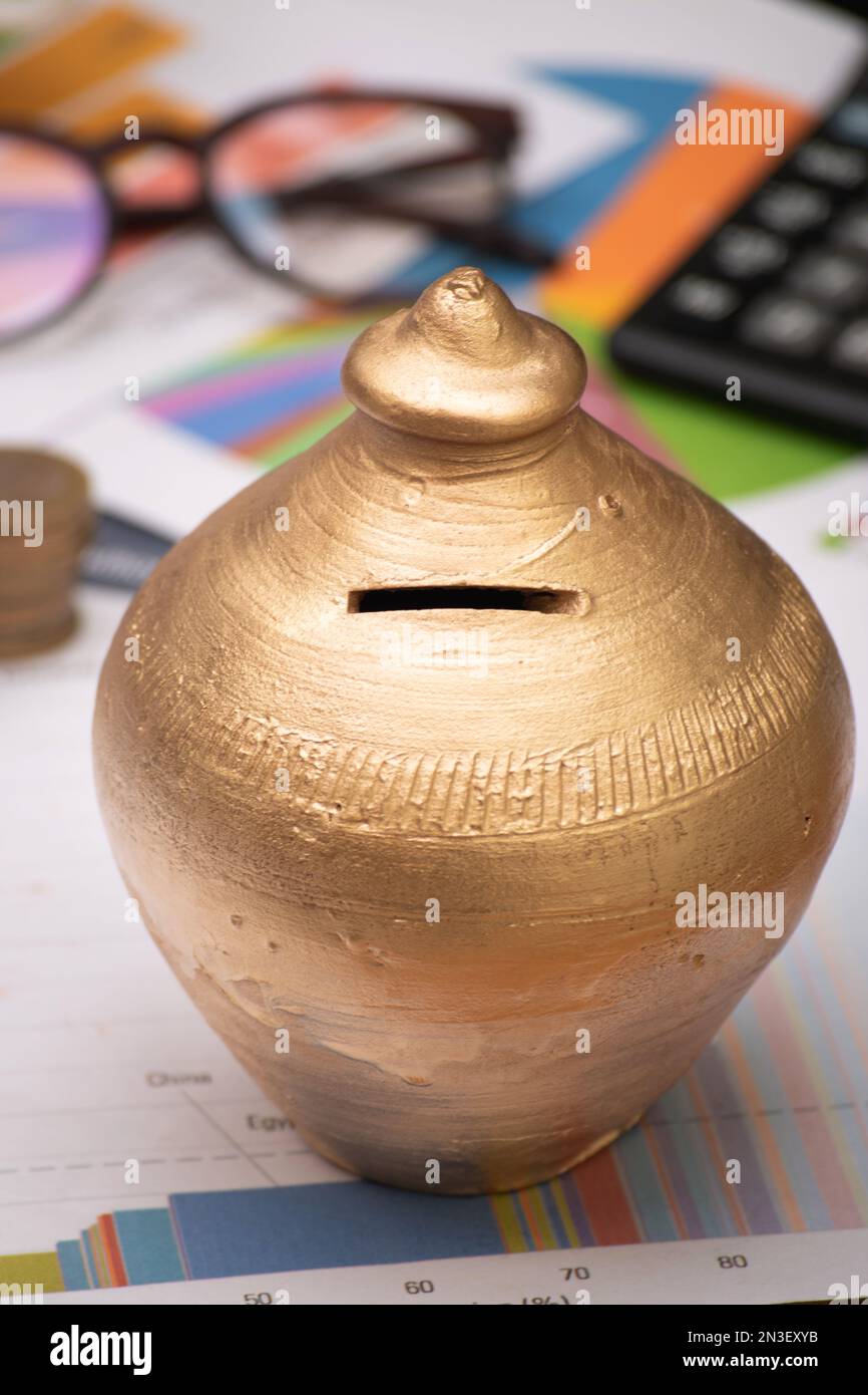 Golden gullak at table,saving money concept india Stock Photo Alamy