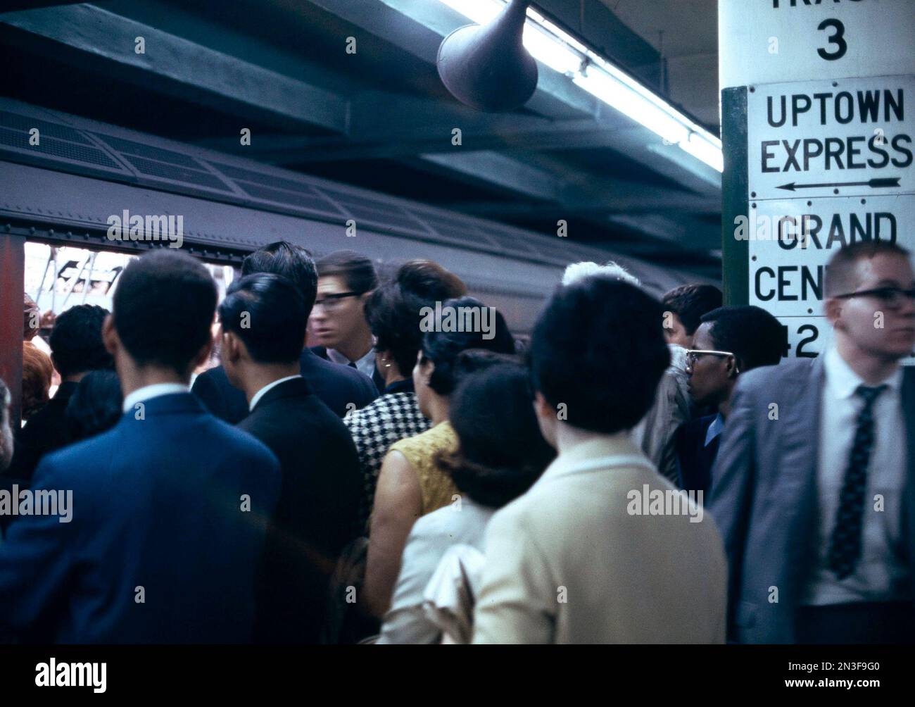 Passengers jockey for position to enter an uptown express train at the