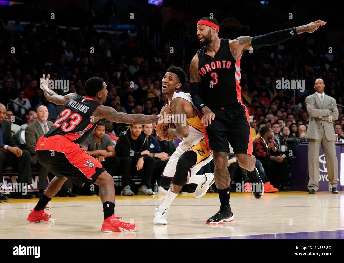 Los Angeles Lakers' Nick Young, center, is pressured by Toronto Raptors