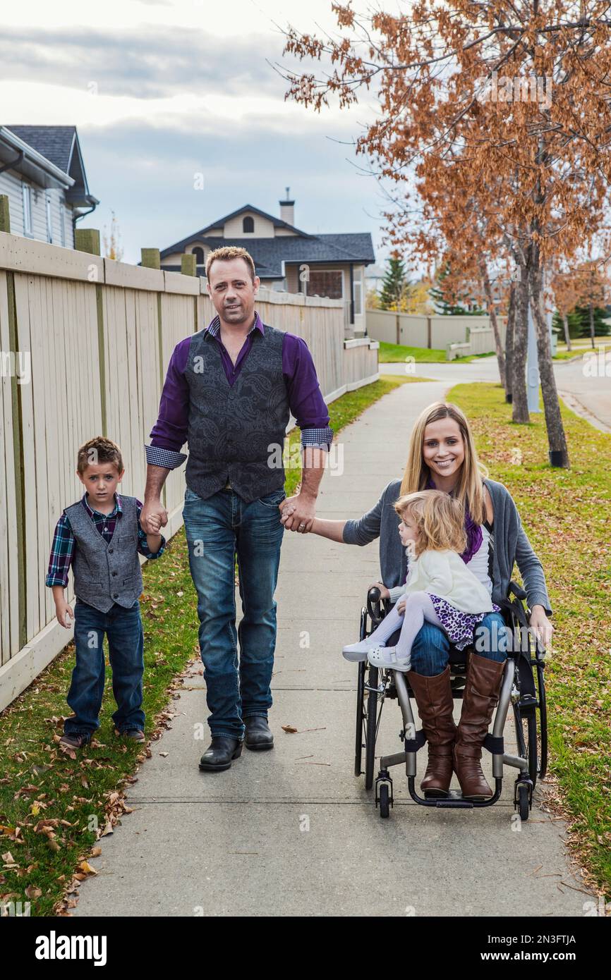 Disabled mother spending quality time with her family outdoors; Spruce Grove, Alberta, Canada Stock Photo