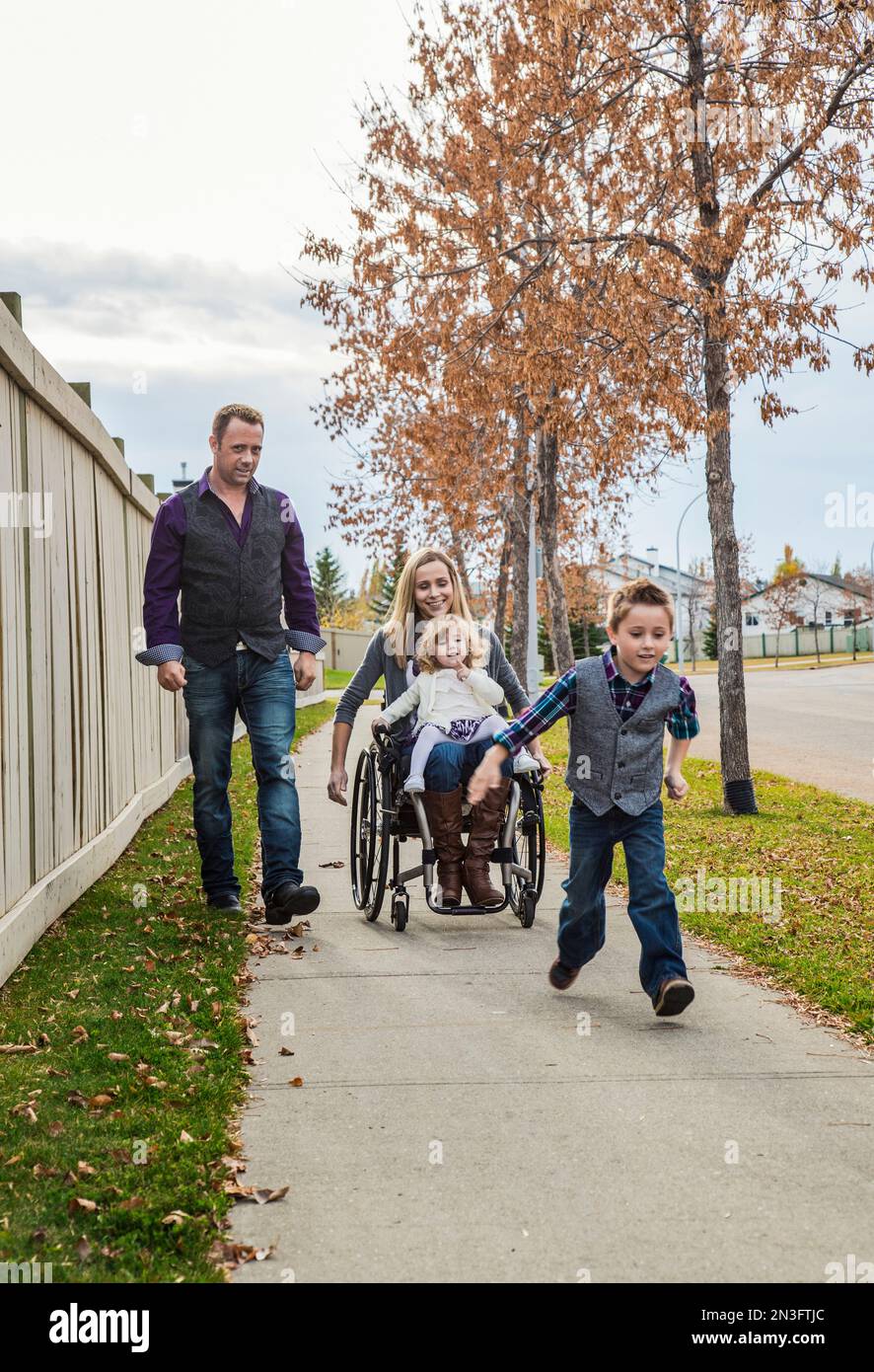 Disabled mother spending quality time with her family outdoors; Spruce Grove, Alberta, Canada Stock Photo