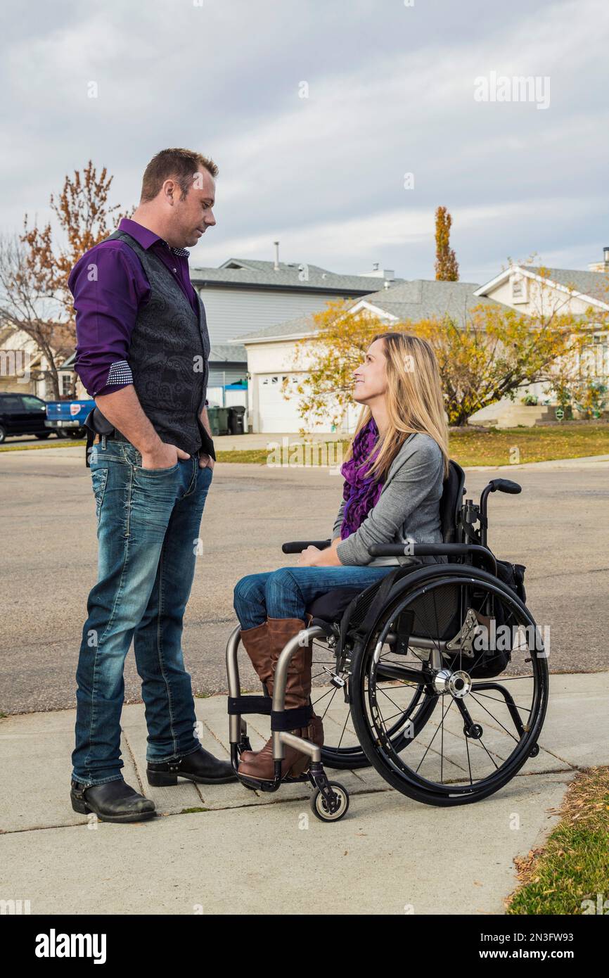 Husband and his wife with a disability spending quality time together outdoors; Spruce Grove, Alberta, Canada Stock Photo