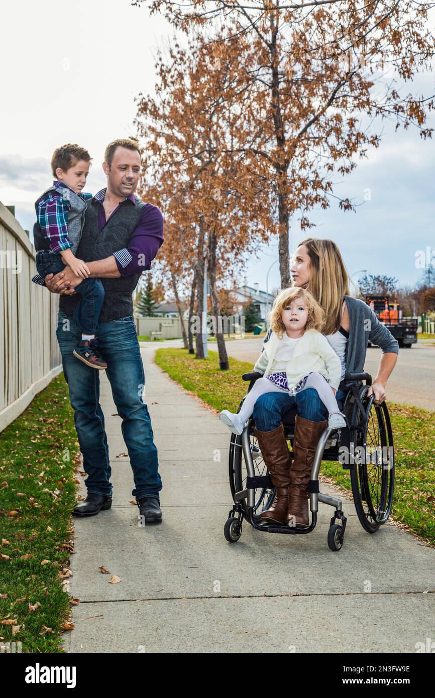 Disabled mother spending quality time with her family outdoors; Spruce Grove, Alberta, Canada Stock Photo