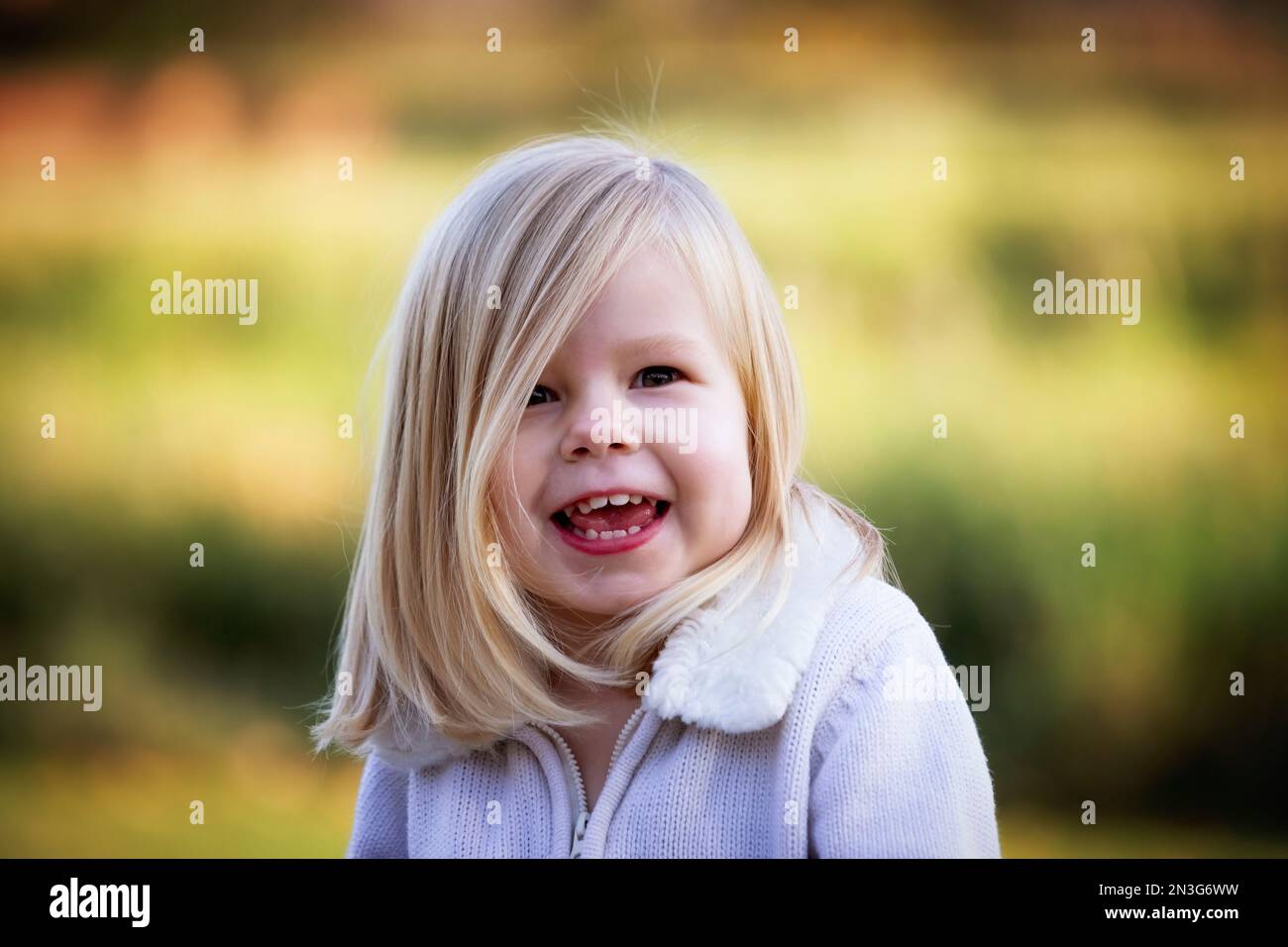 Young girl posing for a portrait in a city park during the fall season; St. Albert, Alberta, Canada Stock Photo