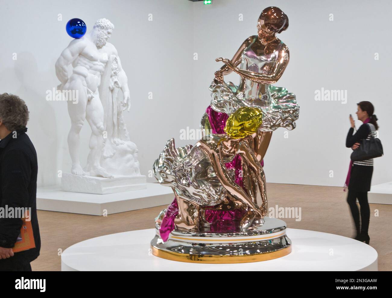 Visitors walk past "Gazing Ball (farnese Hercules) 2013", left, and