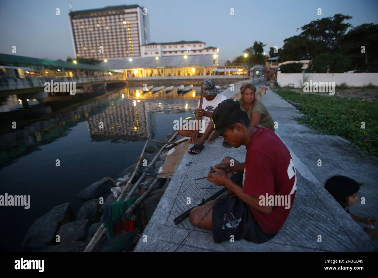 Filipino fisherman Gil Calleo prepares his fishing gear near the Manila  Hotel in Manila, Philippines on Tuesday, Nov. 25, 2014. Calleo spends a  week fishing along Manila Bay and then returns home