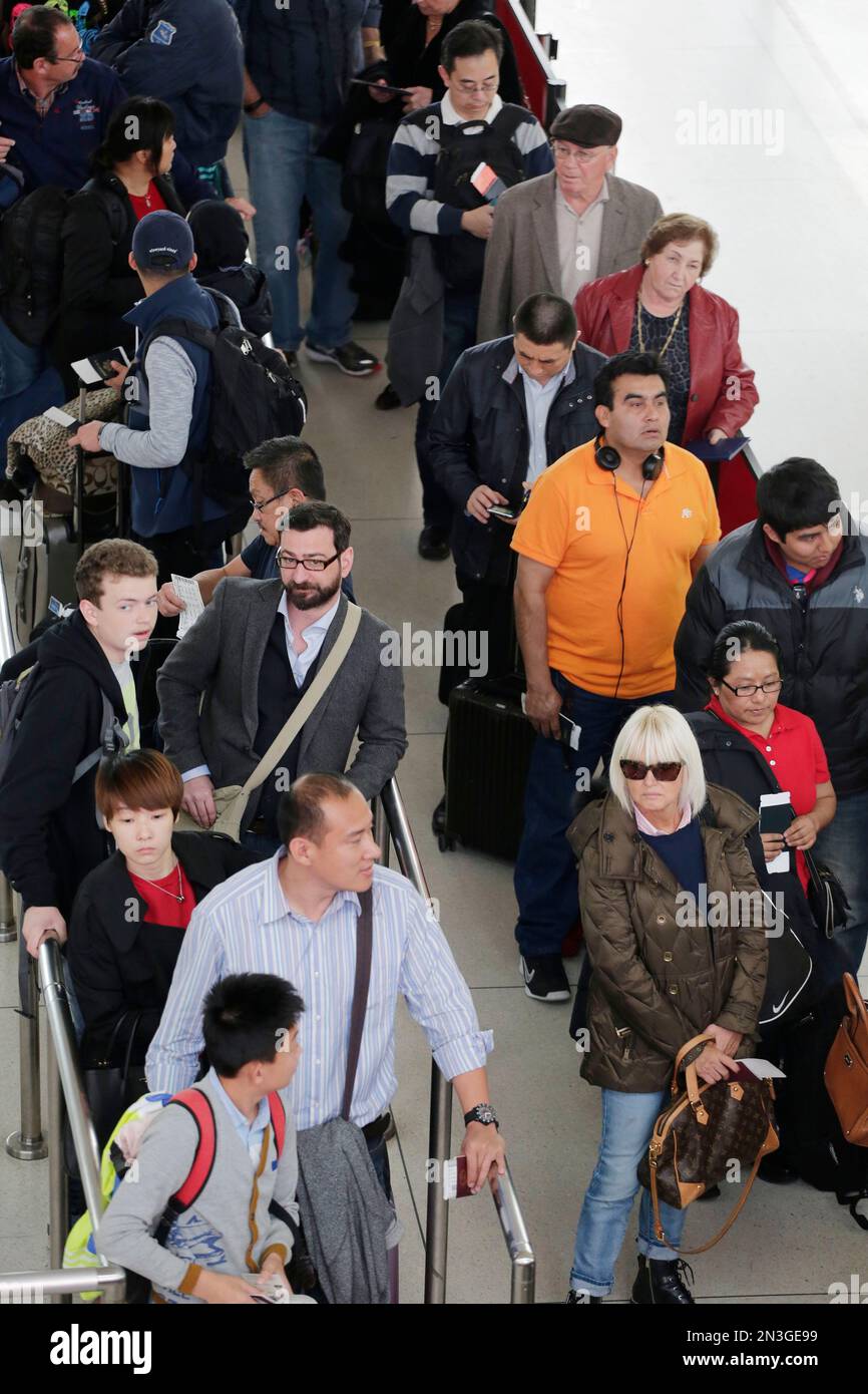 Passengers line up to pass through security before boarding flights at