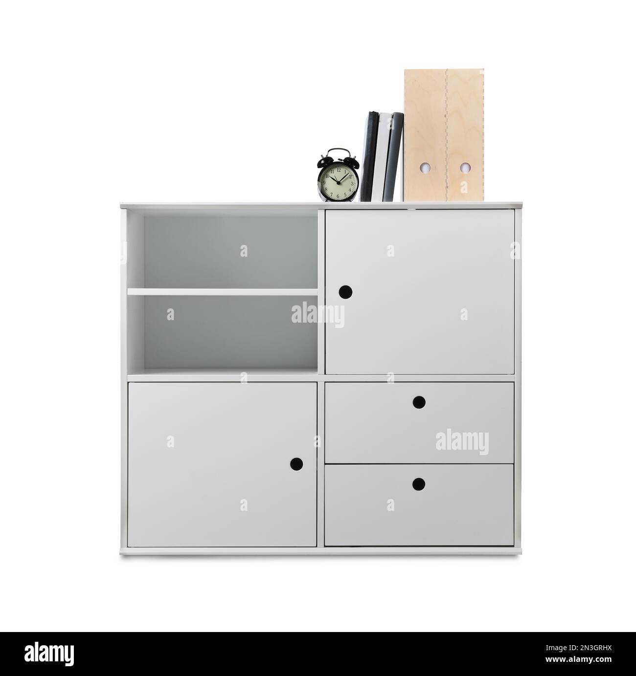 Stylish shelving unit with alarm clock and books isolated on white