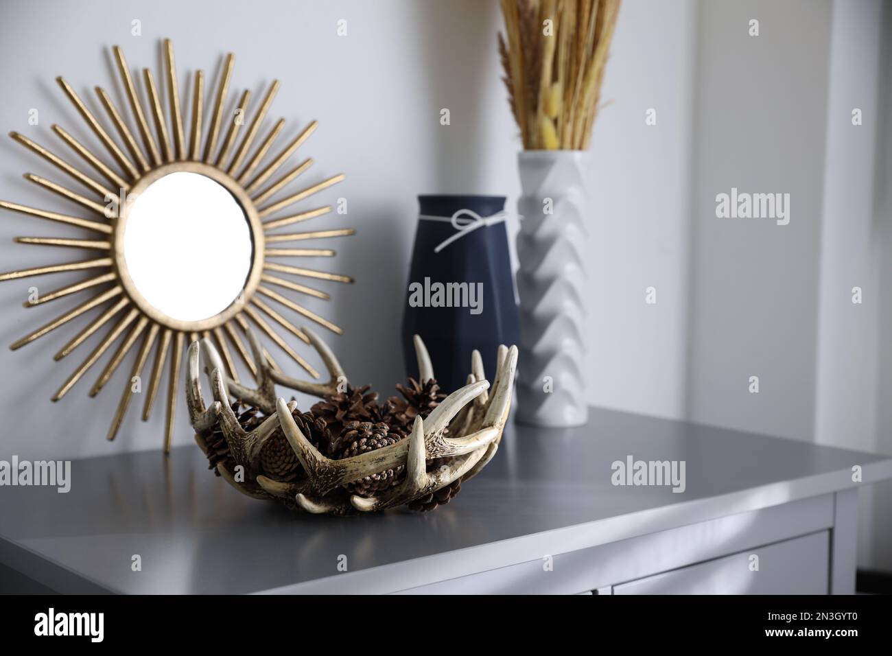Stylish decor and mirror on commode. Interior design Stock Photo - Alamy