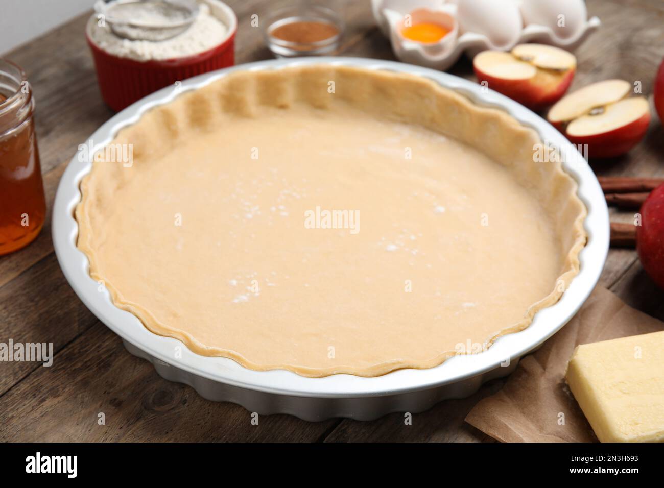 Raw dough for traditional English apple pie on wooden table, closeup Stock Photo