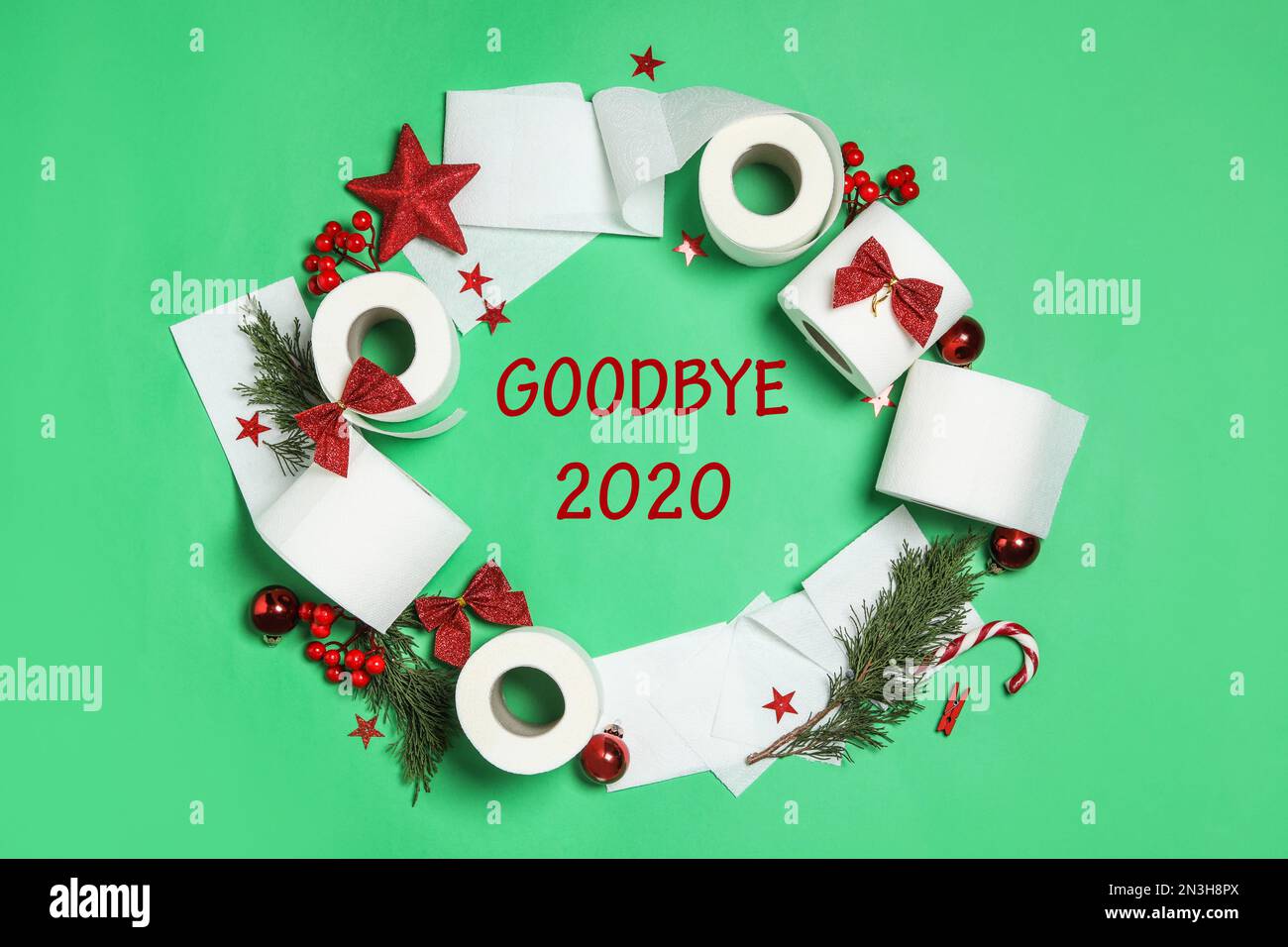 Flat lay composition with text Goodbye 2020 and toilet paper on green background, flat lay Stock Photo