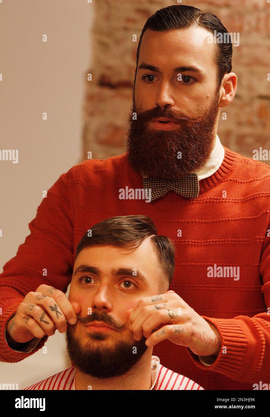 In this Nov. 13, 2014, photo, Salvador Chanza, top, 31, a master barber