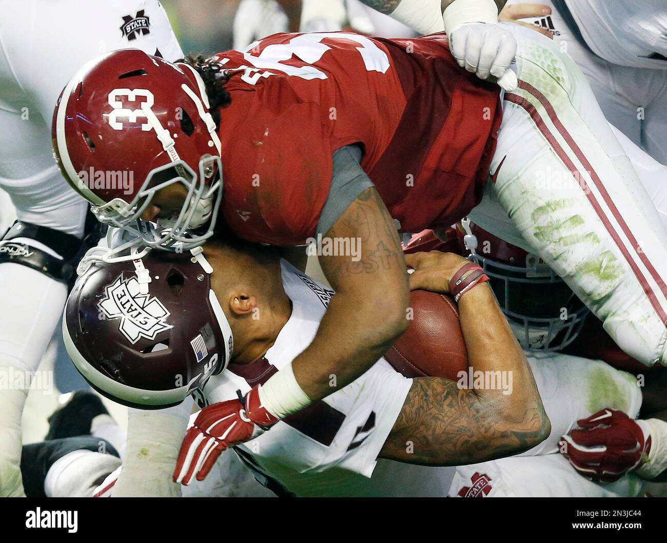 Mississippi State quarterback Dak Prescott, bottom, has his helmet knocked  off by Alabama linebacker Trey DePriest (33) during the second half of an  NCAA college football game Saturday, Nov. 15, 2014, in