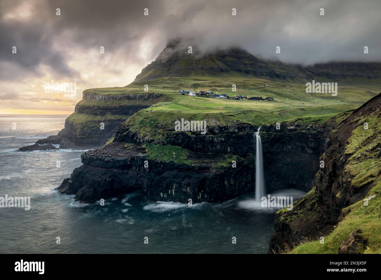 A Scenic Shot Of Mulafossur Waterfall On Coastal Cliff Of Ocean At 