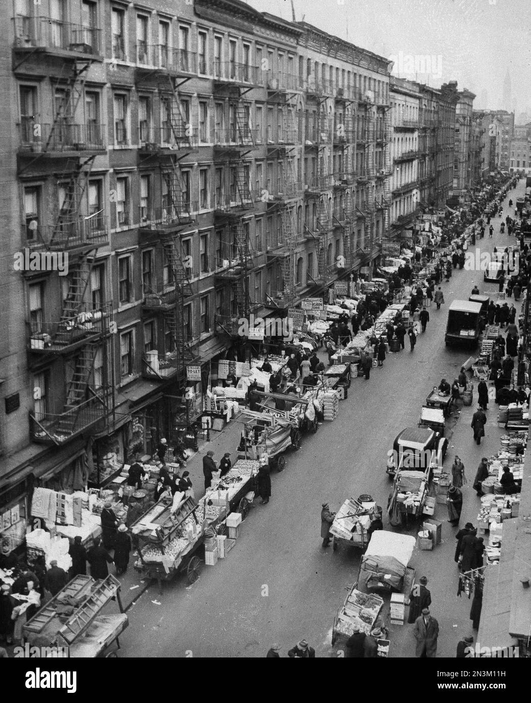 Push carts and street vendors line the teeming sidewalks on a street on ...