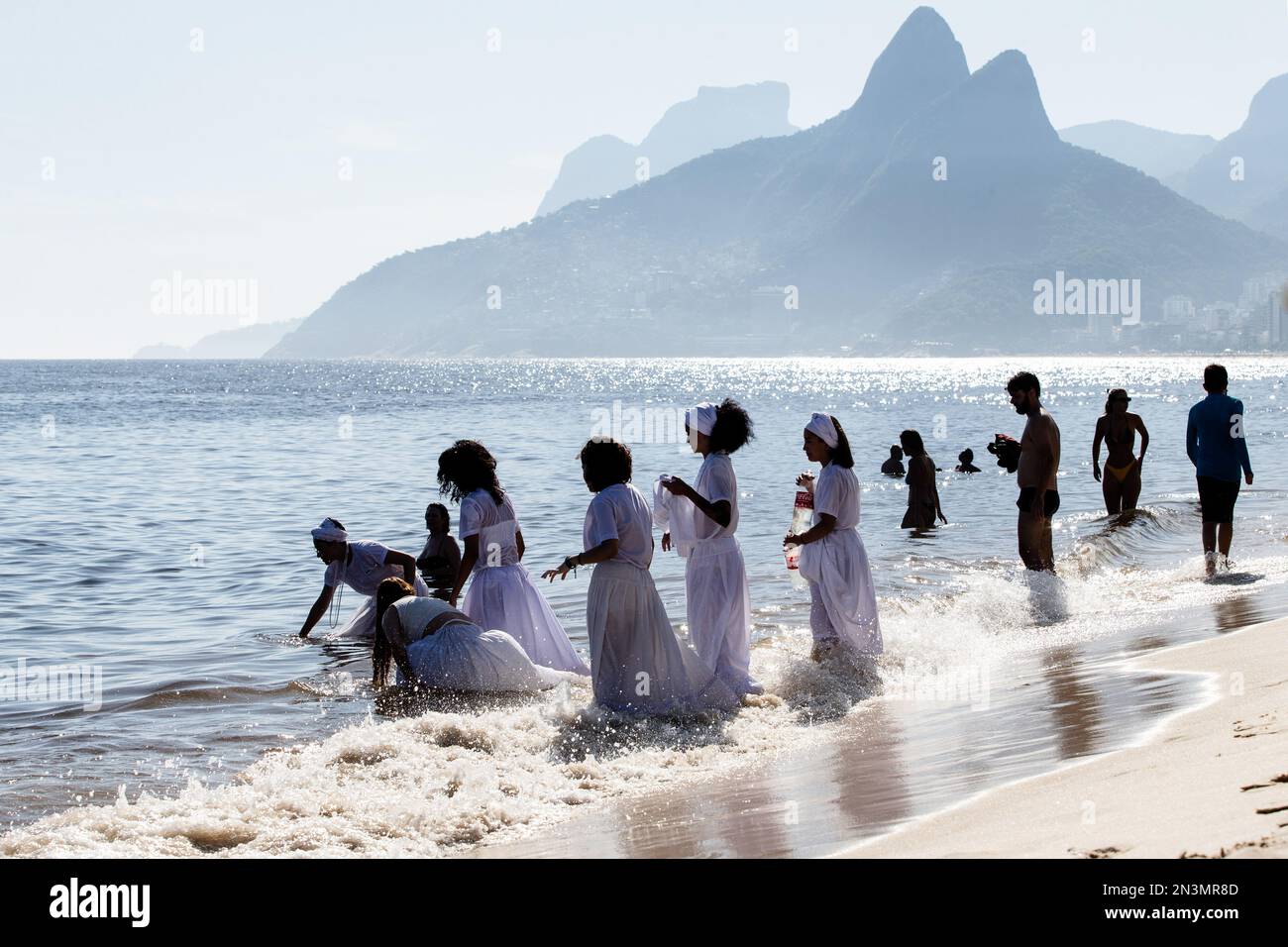 Devotees of Iemanja pray and jump waves in celebration of their goddess. In an event that was modeled after the celebrations on the Rio Vermelho in Salvador, Bahia, Cariocas honored Iemanjá, the west-African goddess of the sea. The festival praised Brazil's most well-known deity with jongo, afoxé, samba, and maracatu music and dances, uniting centennial traditions from both communities, Umbanda and Candomblé. The event was held in Arpoador, Rio de Janeiro, for the first time, idealized by the musician Marcos André. Stock Photo