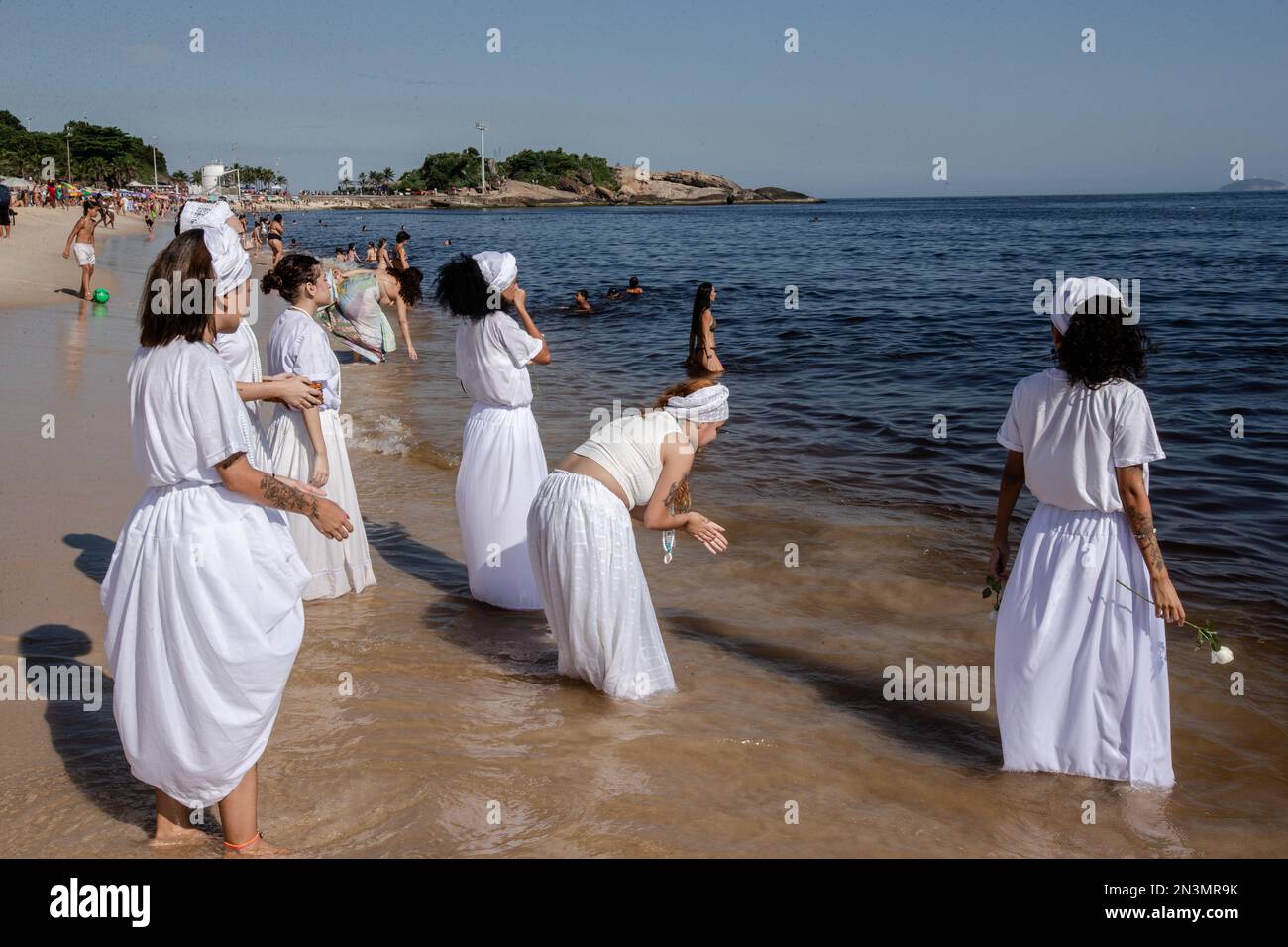 Devotees of Iemanja pray and jump waves in celebration of their goddess. In an event that was modeled after the celebrations on the Rio Vermelho in Salvador, Bahia, Cariocas honored Iemanjá, the west-African goddess of the sea. The festival praised Brazil's most well-known deity with jongo, afoxé, samba, and maracatu music and dances, uniting centennial traditions from both communities, Umbanda and Candomblé. The event was held in Arpoador, Rio de Janeiro, for the first time, idealized by the musician Marcos André. Stock Photo