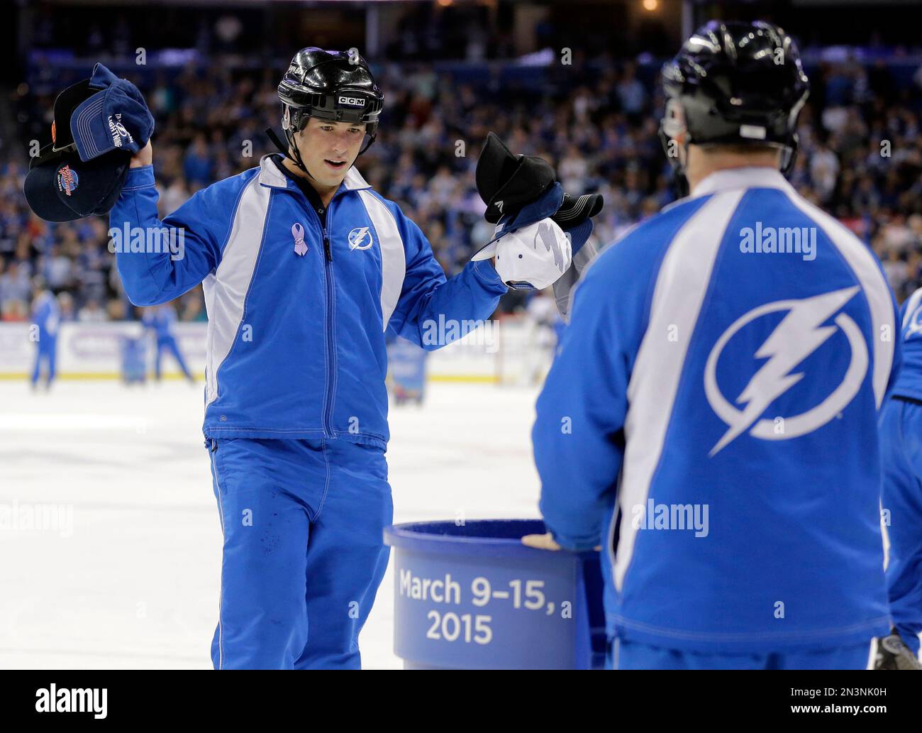 A member of the Tampa Bay Lightning ice crew picks up hats after right