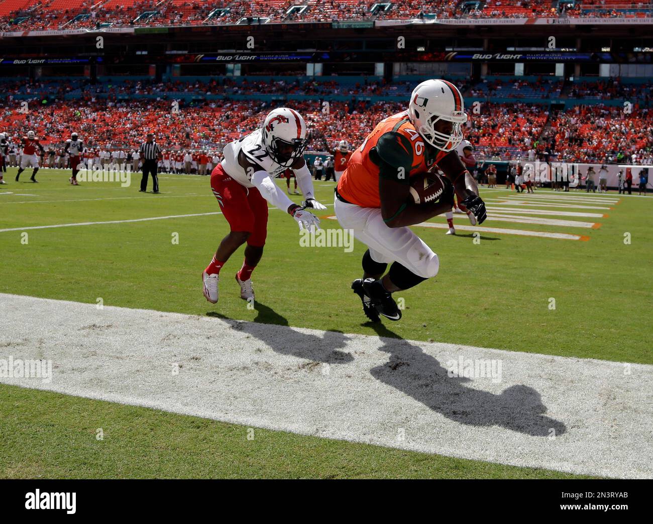 Miami tight end Clive Walford goes into the end zone for a touchdown as Cincinnati safety defends Zach Edwards in the first half of an NCAA college football game Saturday Oct. 11