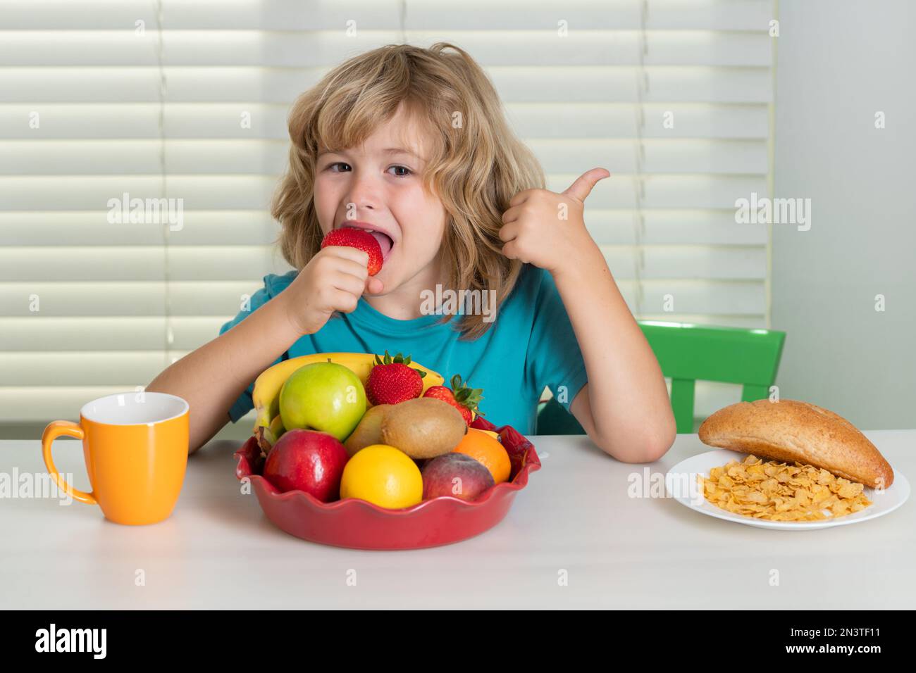 Child eats strawberry, organic fruits. Kid preteen boy 7, 8, 9 years