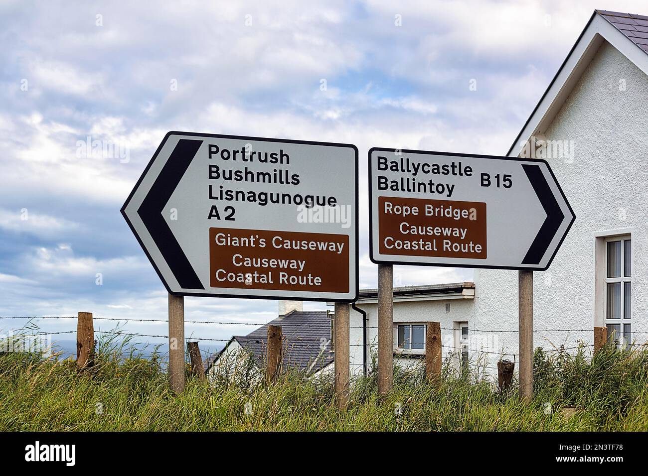 Two directional signs, left and right, Coastal Route, Causeway Coastal Route, Rope Bridge, County Antrim, Northern Ireland, United Kingdom Stock Photo