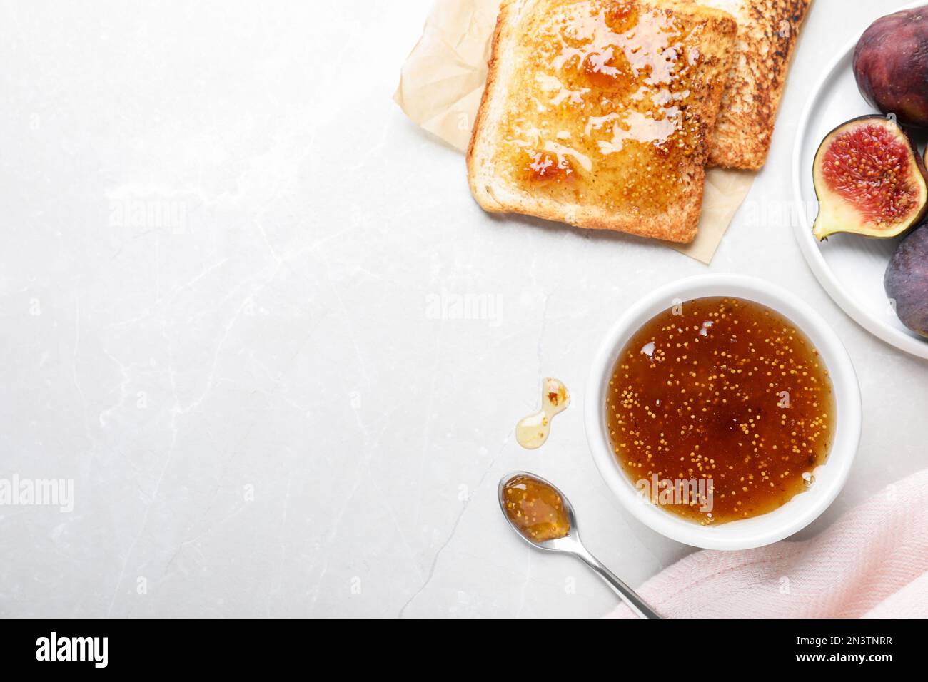 Flat lay composition with delicious fig jam on light grey table. Space ...