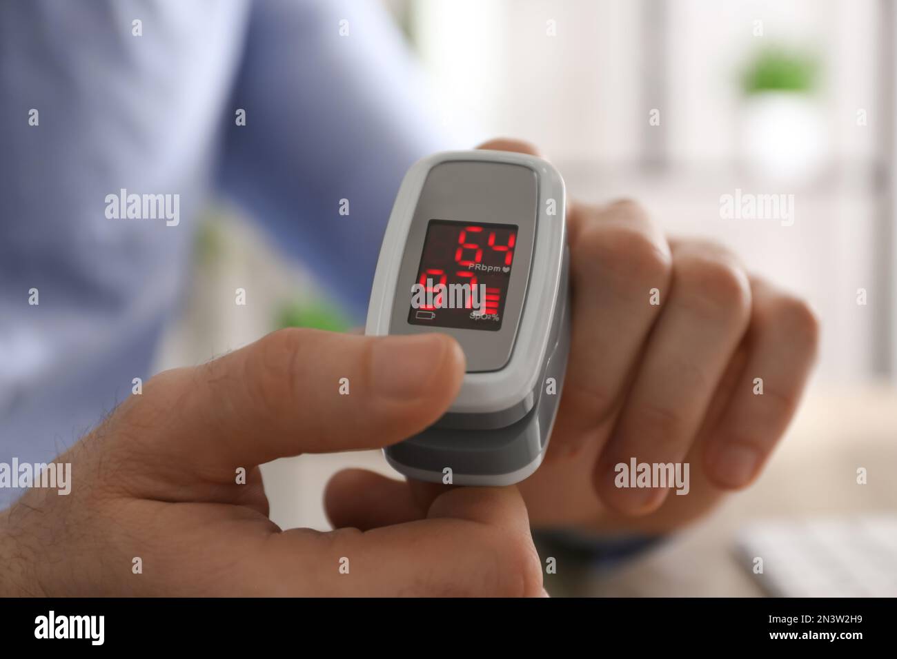 Man measuring oxygen level with modern fingertip pulse oximeter at ...