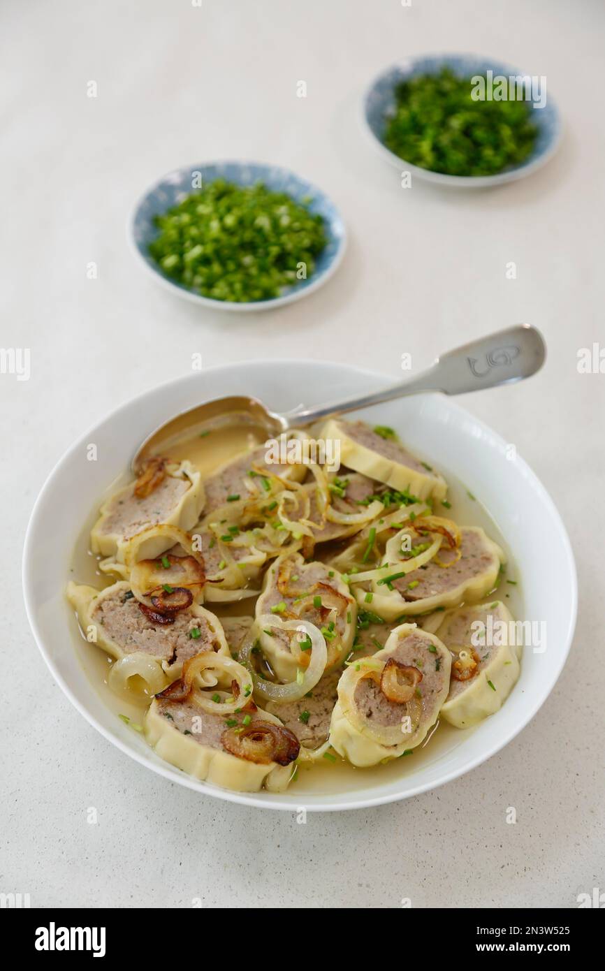 Swabian cuisine, Maultaschen in broth with stewed onions, soup plate, spoon, herbs, Germany Stock Photo