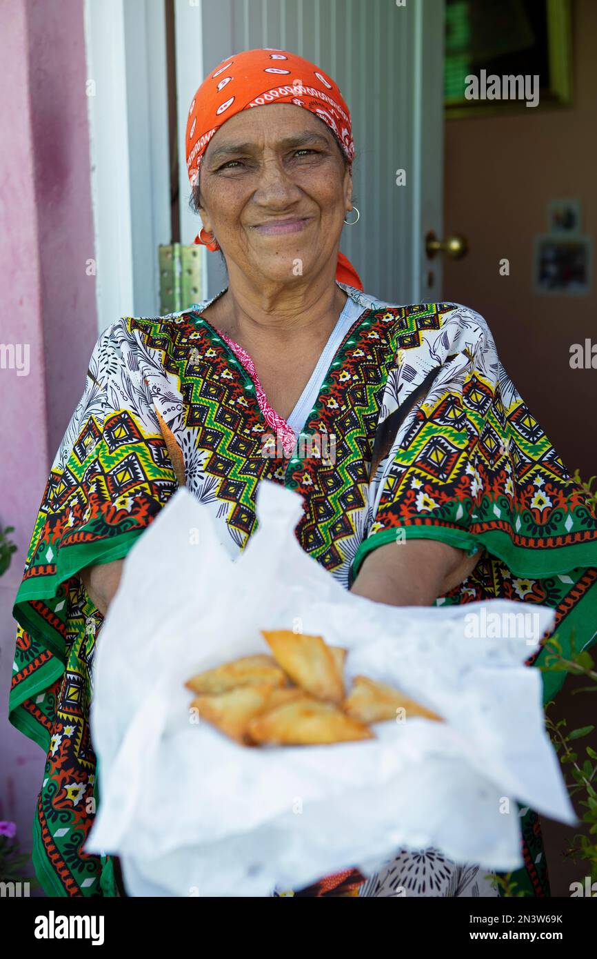 Woman in traditional dress, 68 years, showing Malay dumplings, Bo-Kaap district, Cape Town, Western Cape, South Africa Stock Photo