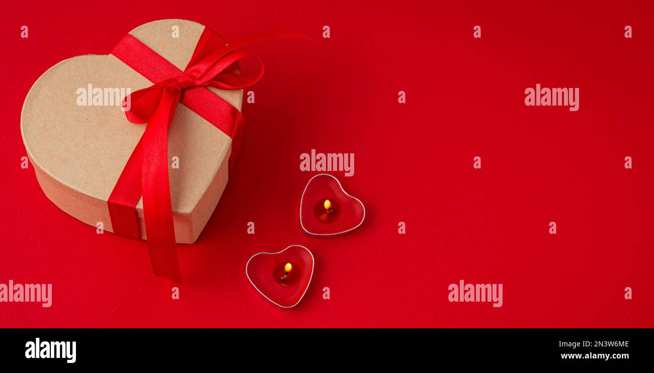 Beautiful minimal wrapped gift box heart shaped with red bow ribbon on ...