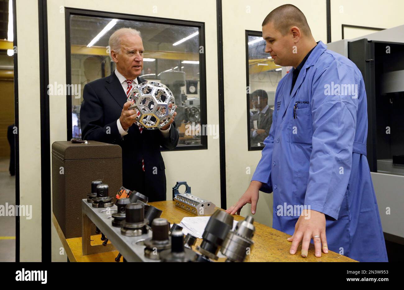 Vice President Joe Biden holds a machine tooled metal ball made in the ...