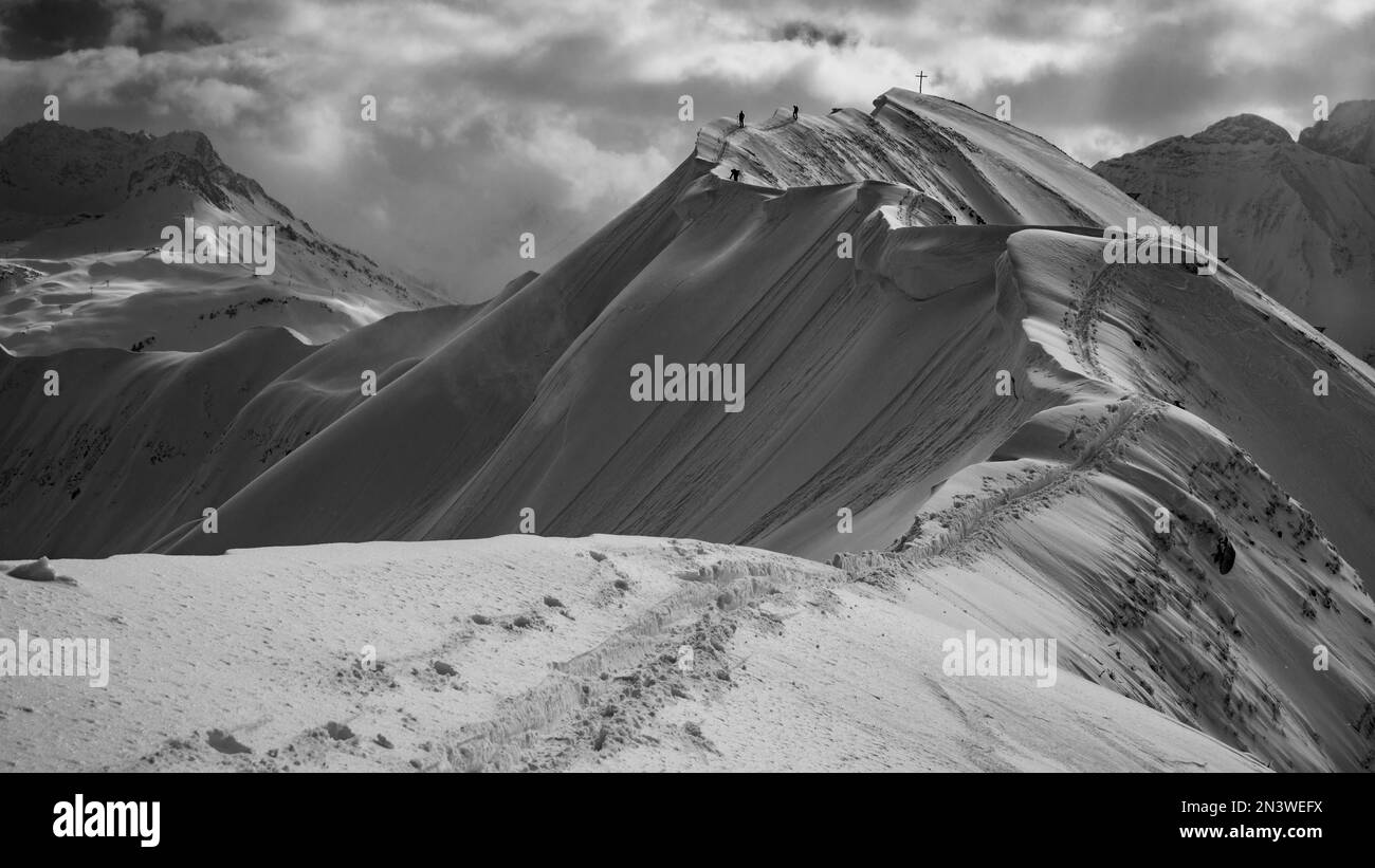 Summit cross of the Hoeferspitze with covered summit ridge and mountaineers, Baad, Kleinwalsertal, Vorarlberg, Austria Stock Photo