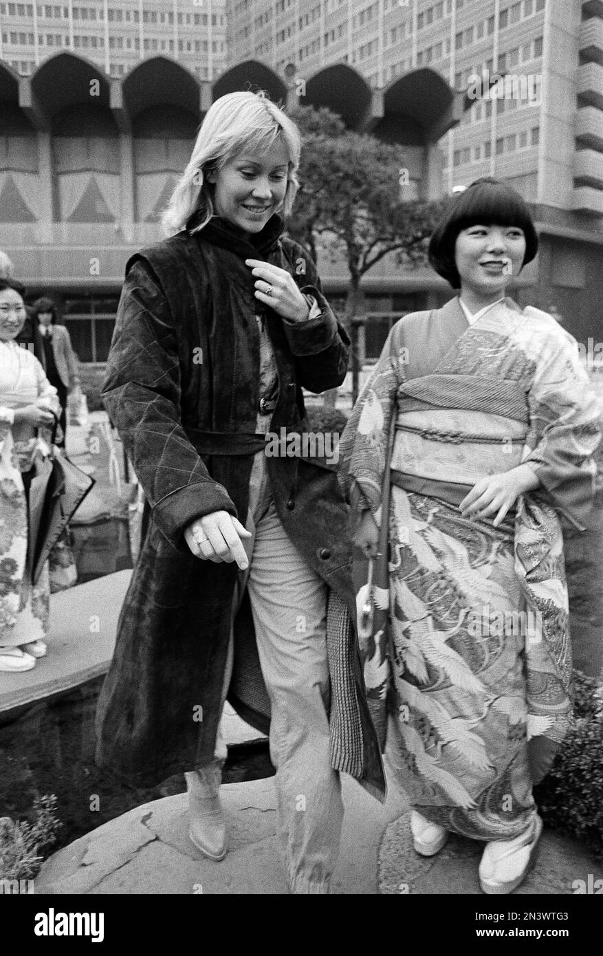 Agnetha Faltskog of the Swedish pop group ABBA walks past an unidentified  Japanese girl in a kimono a the hotel's Japanese garden in Tokyo, where the  group is currently on a concert