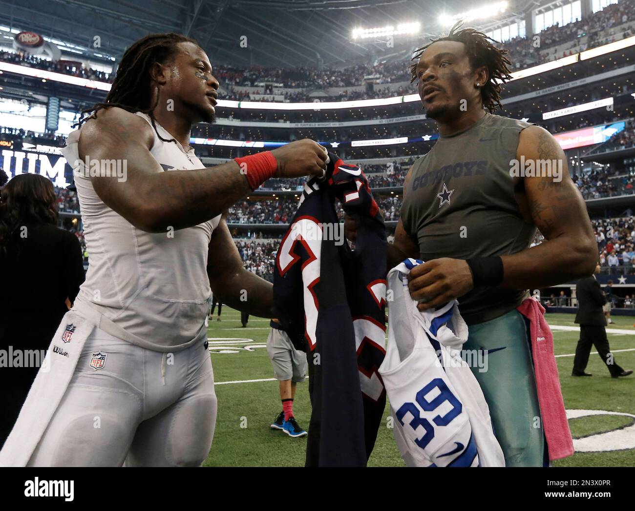 Houston Texans free safety Kendrick Lewis 21 and Dallas Cowboys cornerback Brandon Carr 39 trade jerseys after overtime of an NFL football game Sunday Oct. 5 2014 in Arlington Texas. Dallas won