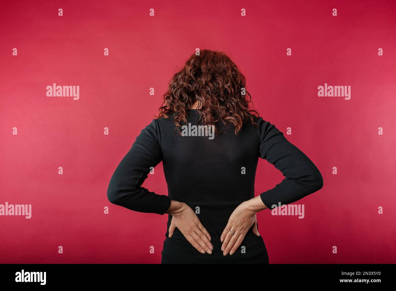 Young caucasian woman wearing black ribbed dress standing isolated over