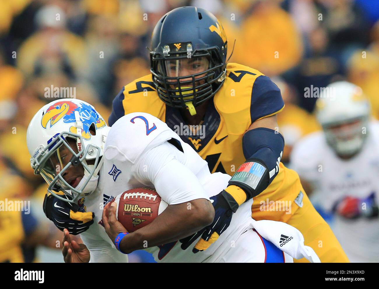 West Virginia's Shaquille Riddick (4) tackles Kansas quarterback ...