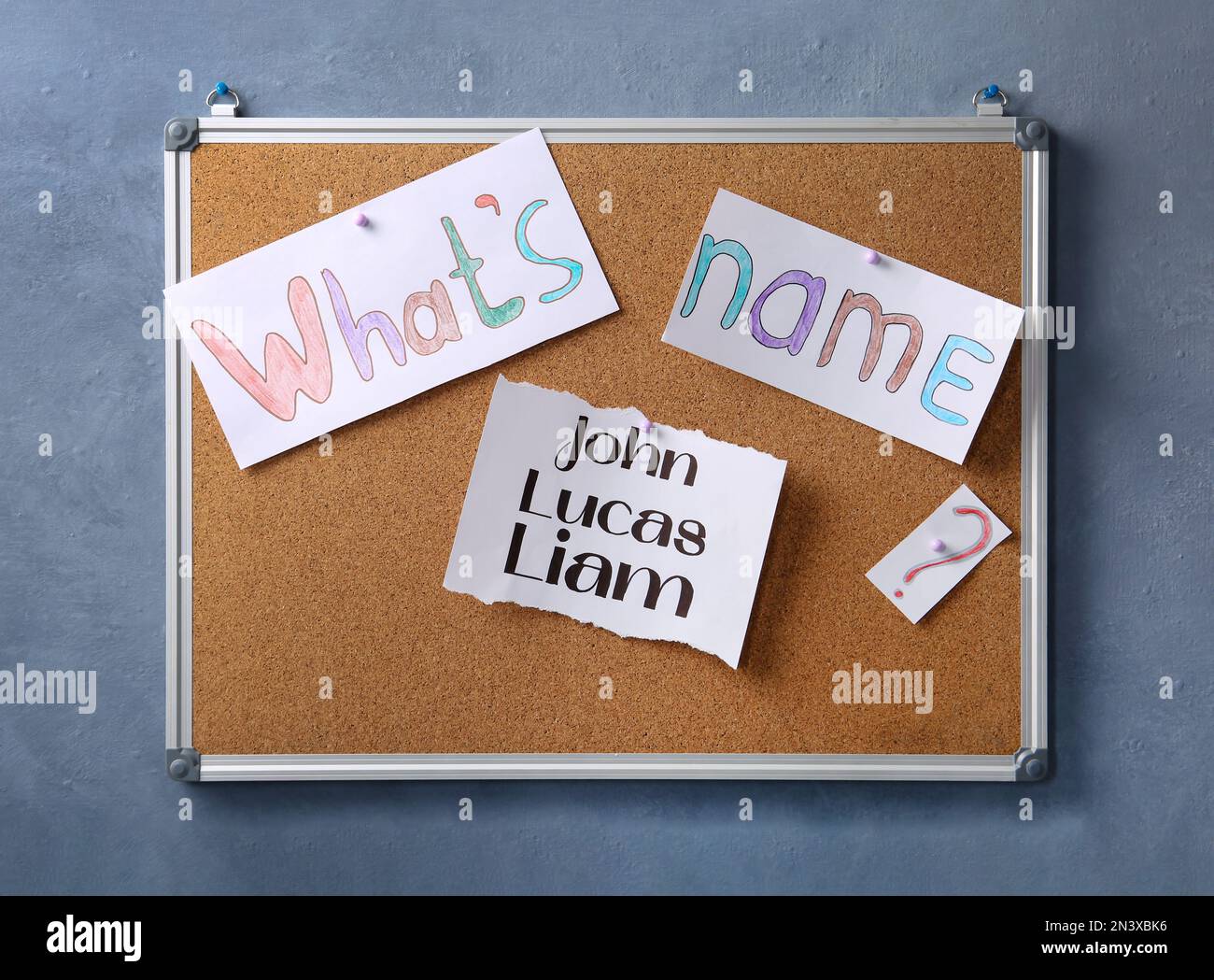 Cork board with baby names hanging on grey wall Stock Photo Alamy