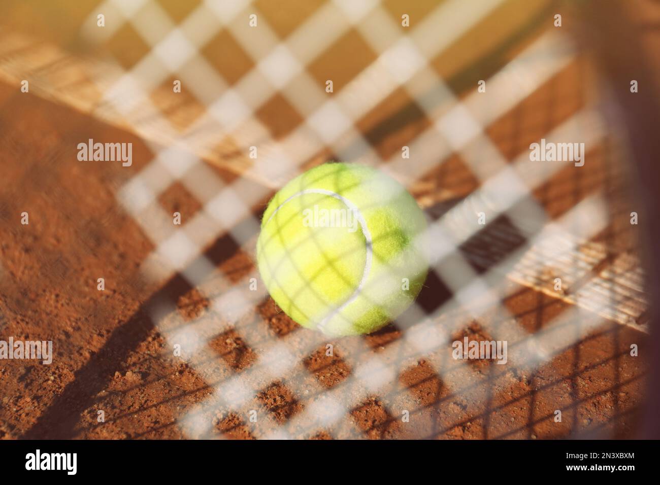 Tennis ball on clay court, view through racket Stock Photo Alamy