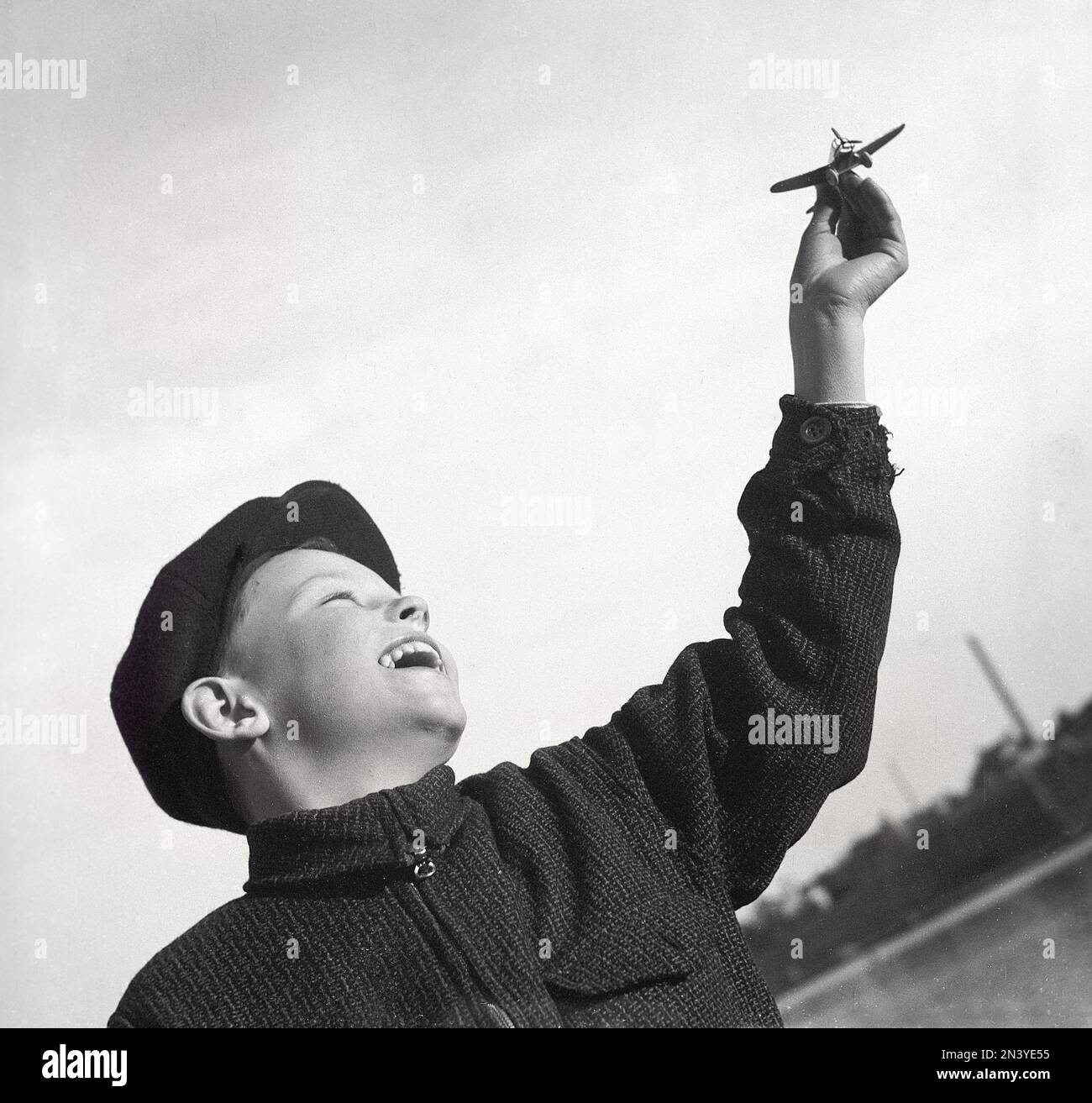 Boy in the 1940s. A boy is seen holding a toy ariplane in his hand, made by the german manufacturer Wiking Modellbau in Berling who was famous for making models, a production that started 193 in the scale 1:200 in metal. Sweden 22 april 1940 Kristoffersson ref 117-11 Stock Photo