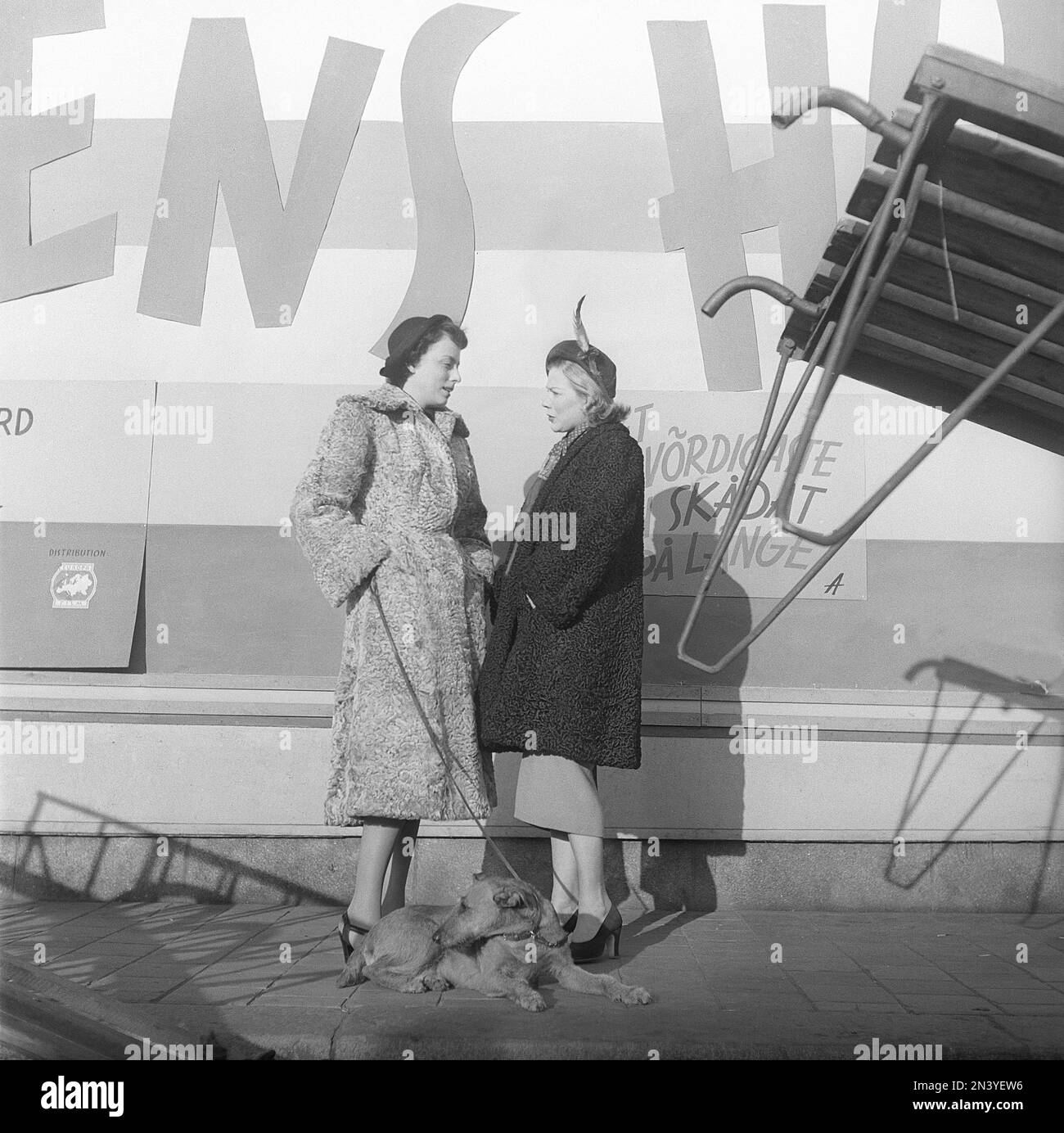 Women's fashion in the 1940s. Two women are standing close each other talking about something. They are wearing warm coats and matching hats. Sweden 1949 Kristoffersson ref AT37-11 Stock Photo