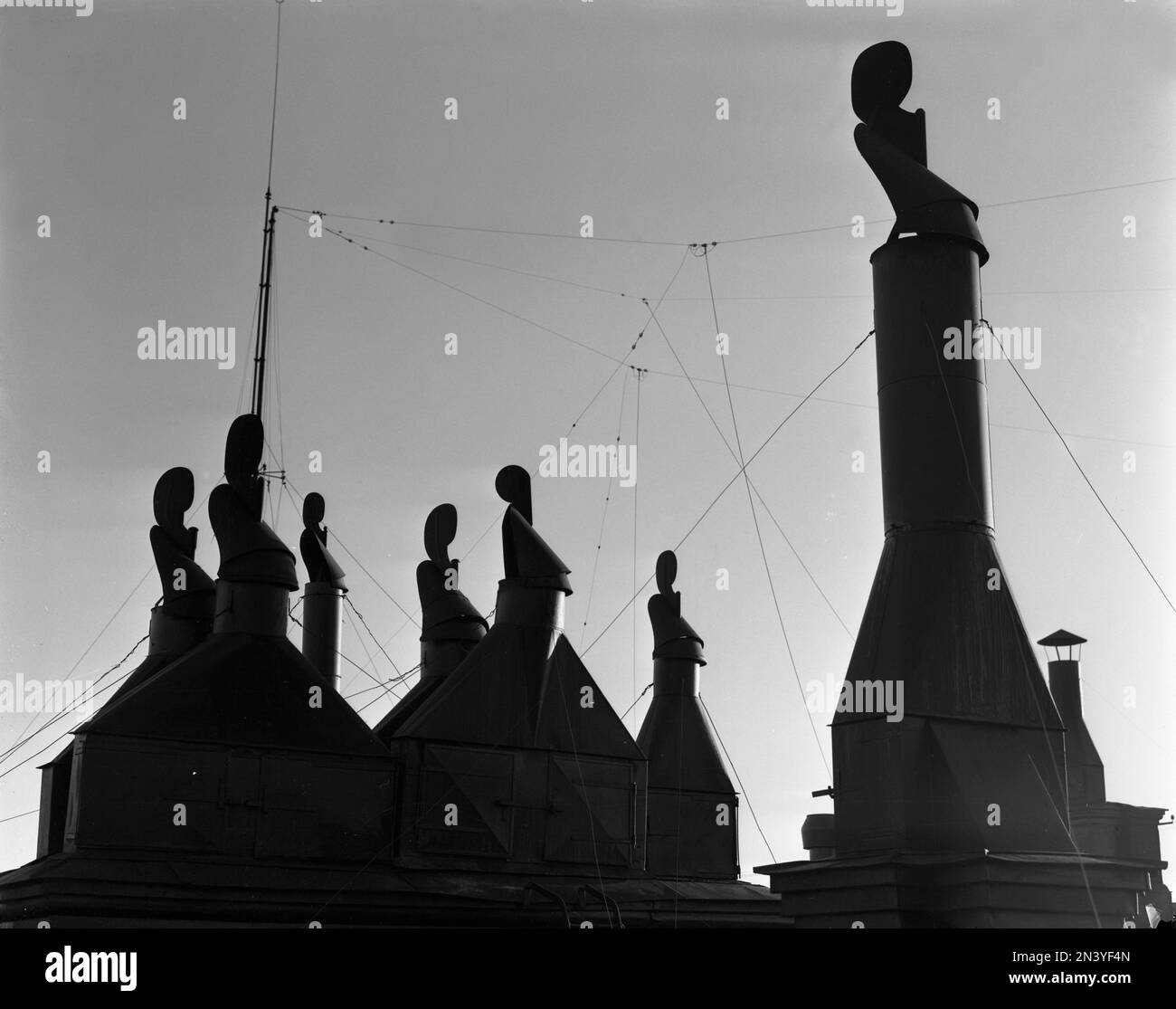 In the 1950s. Detail of chimneys on a rooftop in Stockholm Sweden. The shape and form of the metallic chimneys against the sky is graphical. Sweden 1953 Kristoffersson ref 60K-20 Stock Photo