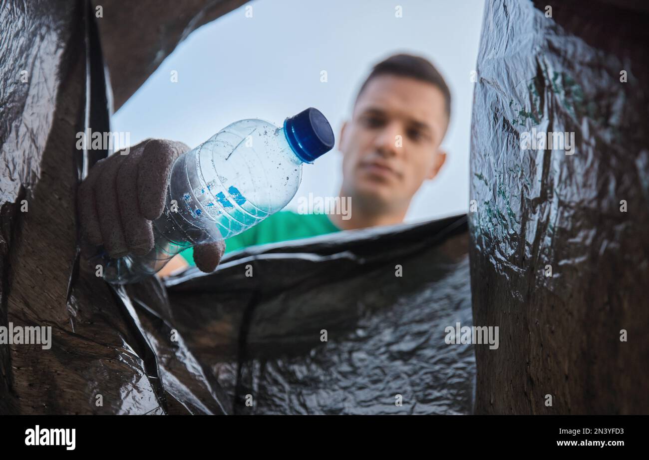 Recycle, bottle and man with view in bag, sustainability and cleaning