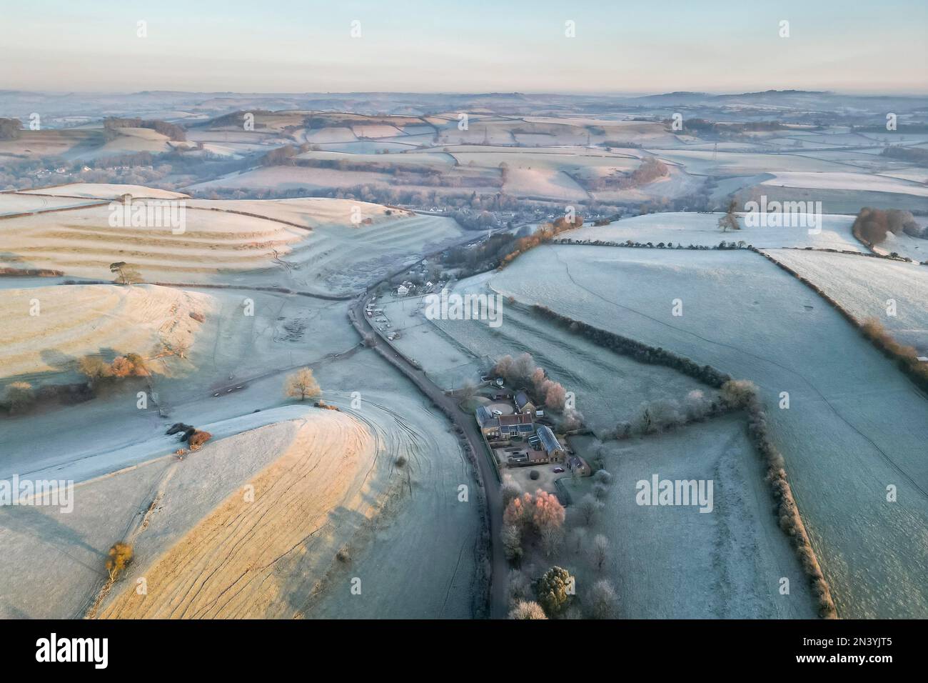 Uploders, Dorset, UK.  8th February 2023.  View from the air of the white frost covered fields at Uploders in Dorset on a clear frosty morning shortly after sunrise after a night of freezing temperatures.  Picture Credit: Graham Hunt/Alamy Live News Stock Photo