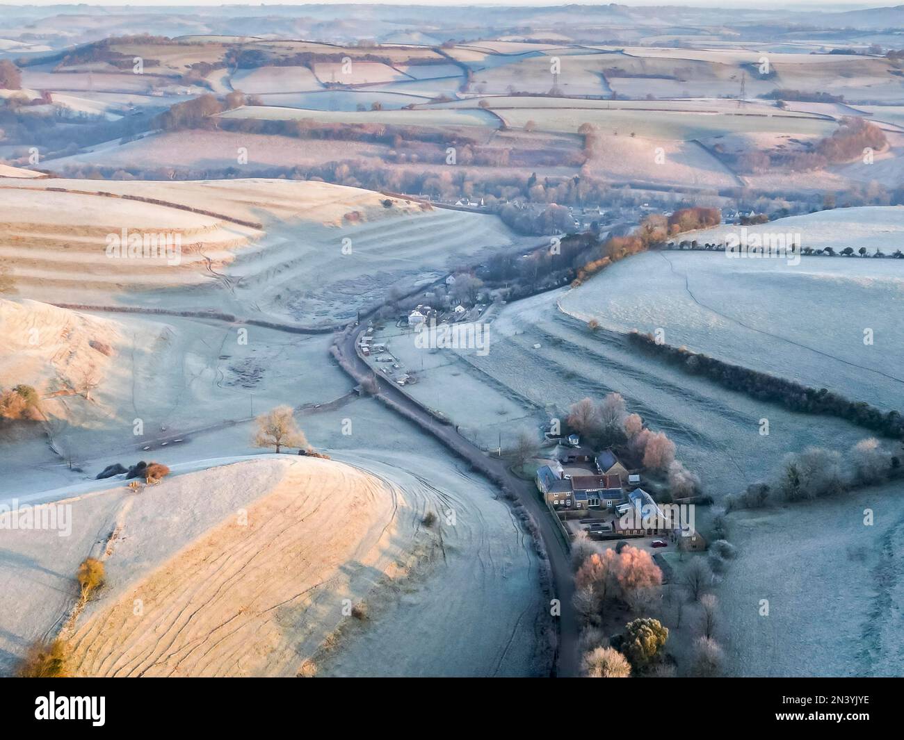 Uploders, Dorset, UK.  8th February 2023.  View from the air of the white frost covered fields at Uploders in Dorset on a clear frosty morning shortly after sunrise after a night of freezing temperatures.  Picture Credit: Graham Hunt/Alamy Live News Stock Photo