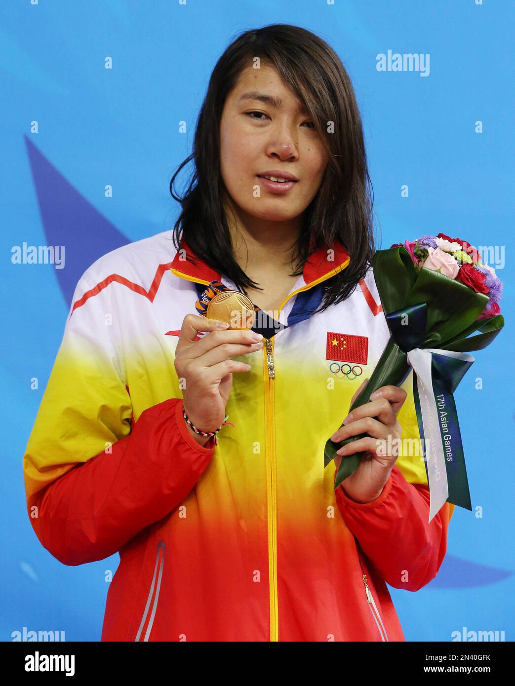 China's Shen Duo holds up her gold medal after winning the women's 200