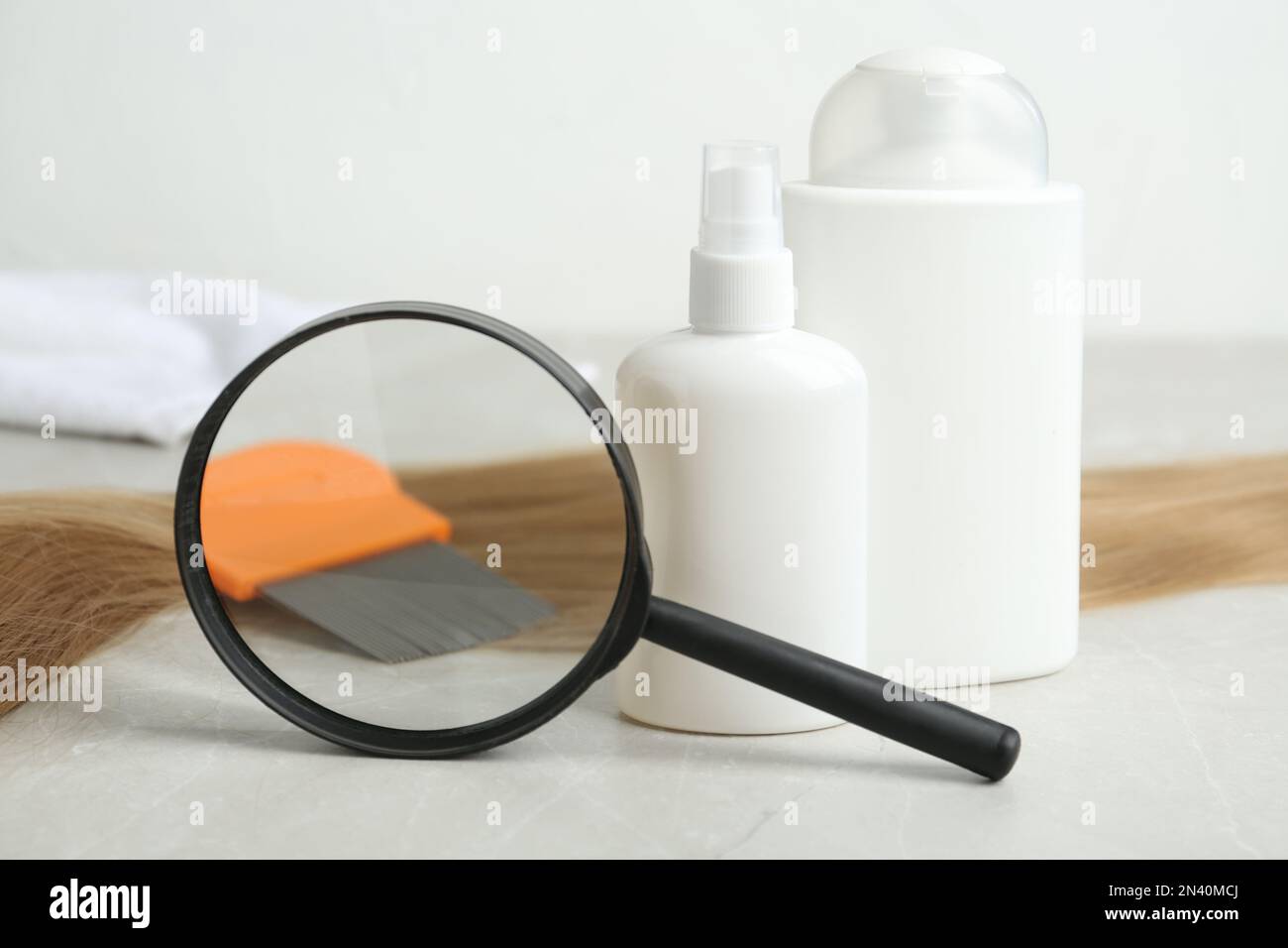 Cosmetic products, lice comb, magnifying glass and strand of hair on